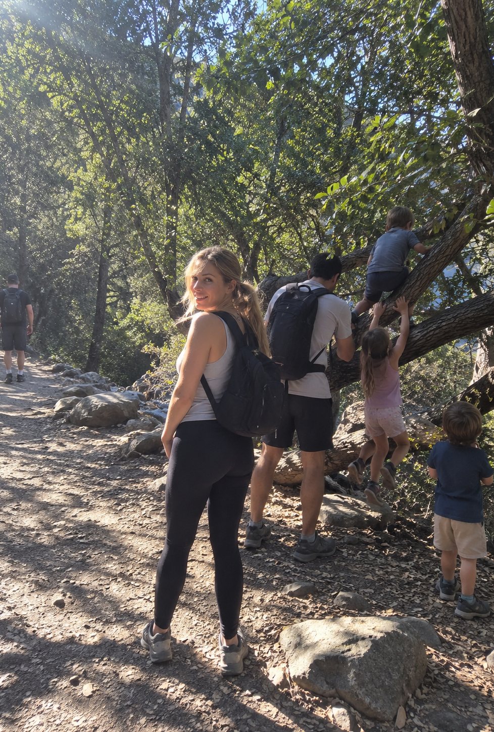 A family walking a trail on a bright afternoon